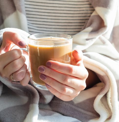 About Page-3 An woman holding a glass mug of coffee